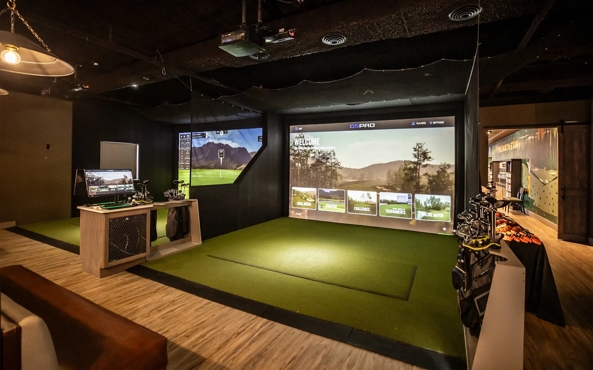 Golfer practicing in an indoor golf simulator bay